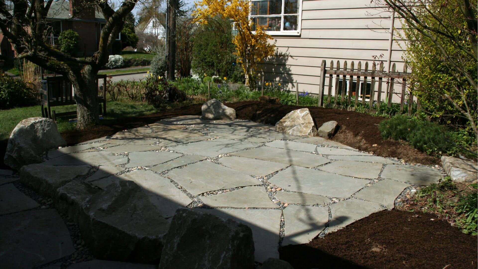 Flagstone pathway installed through a landscaped yard