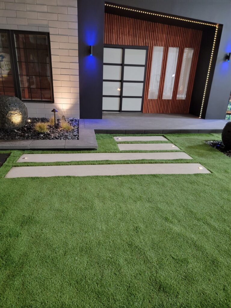 Artificial turf with concrete stepping stones outside a building entrance